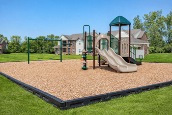 A playground with a slide, swings, and a green tower.